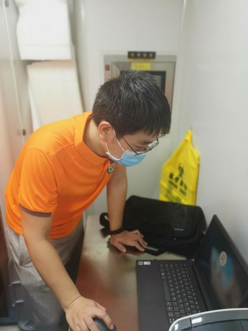 兰宇在支援灵山移动核酸检测车上调试上报系统